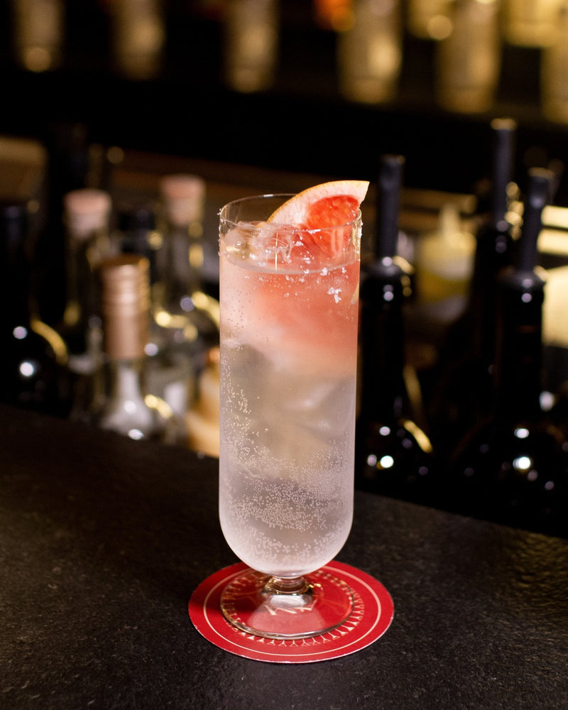 The Levrette, a tall grapefruit and vodka cocktail with a grapefruit wedge, served at the bar